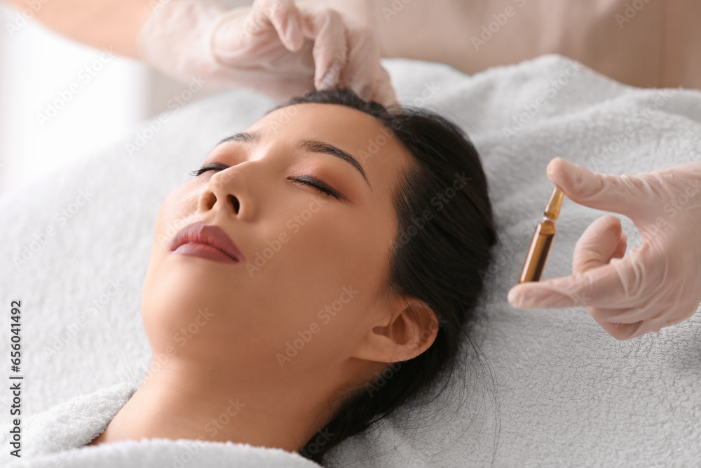 Young Asian woman undergoing treatment in beauty salon. Skin care concept