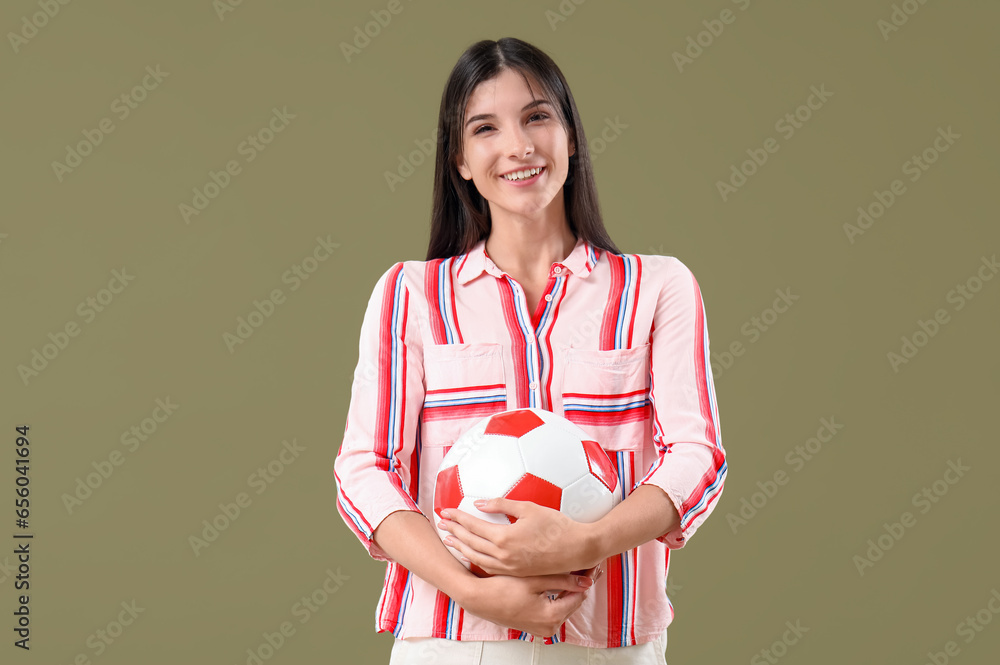 Young woman with soccer ball on color background