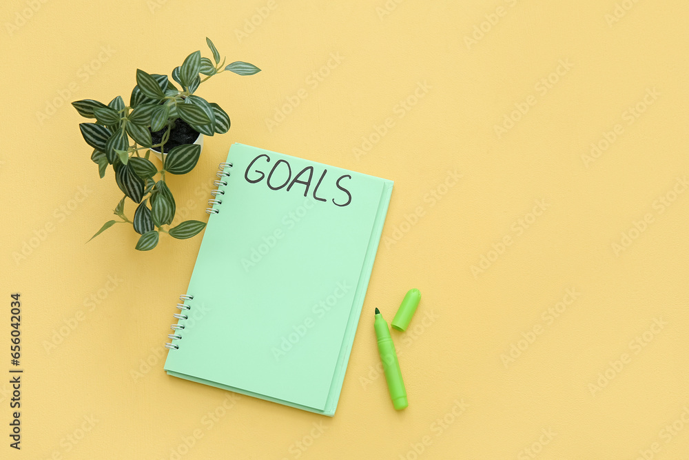 Notebook with empty to do list, marker and houseplant on yellow background. New year goals