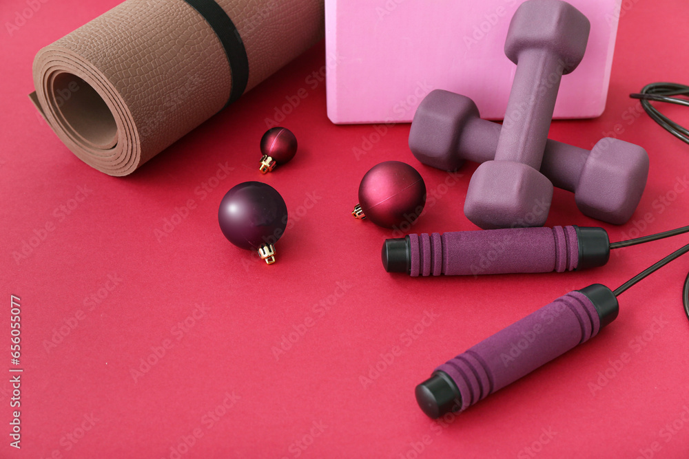 Sports equipment with Christmas decor on red background, closeup