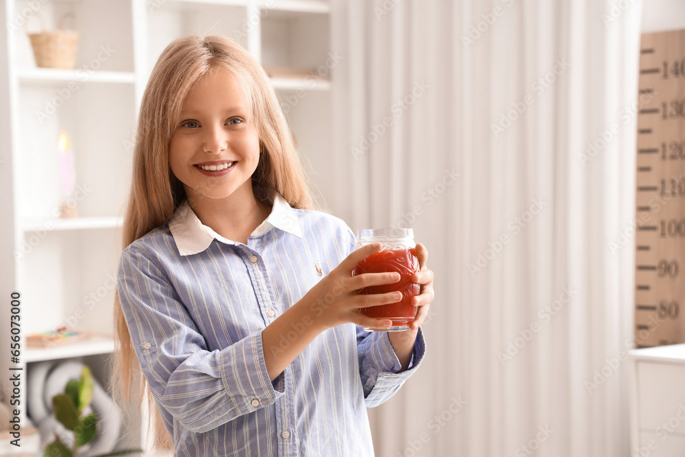 Little girl with glass of juice at home