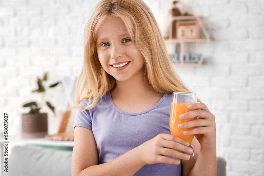 Little girl with glass of juice at home