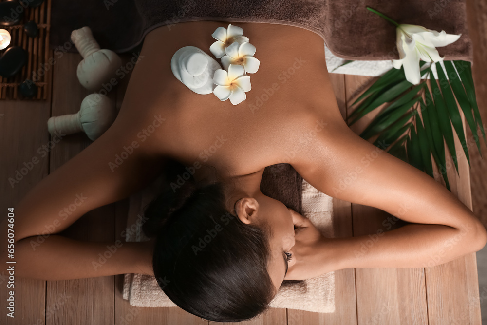 Attractive woman relaxing in spa salon, top view