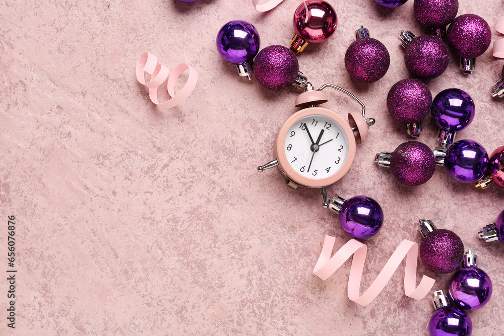 Alarm clock and Christmas balls on pink background