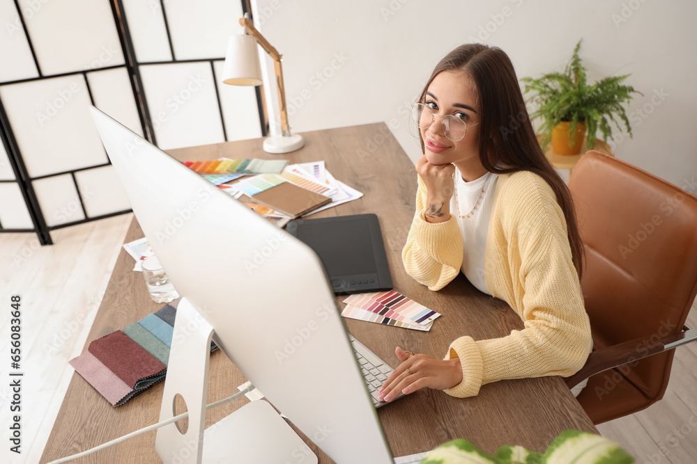 Female interior designer working with computer at table in office