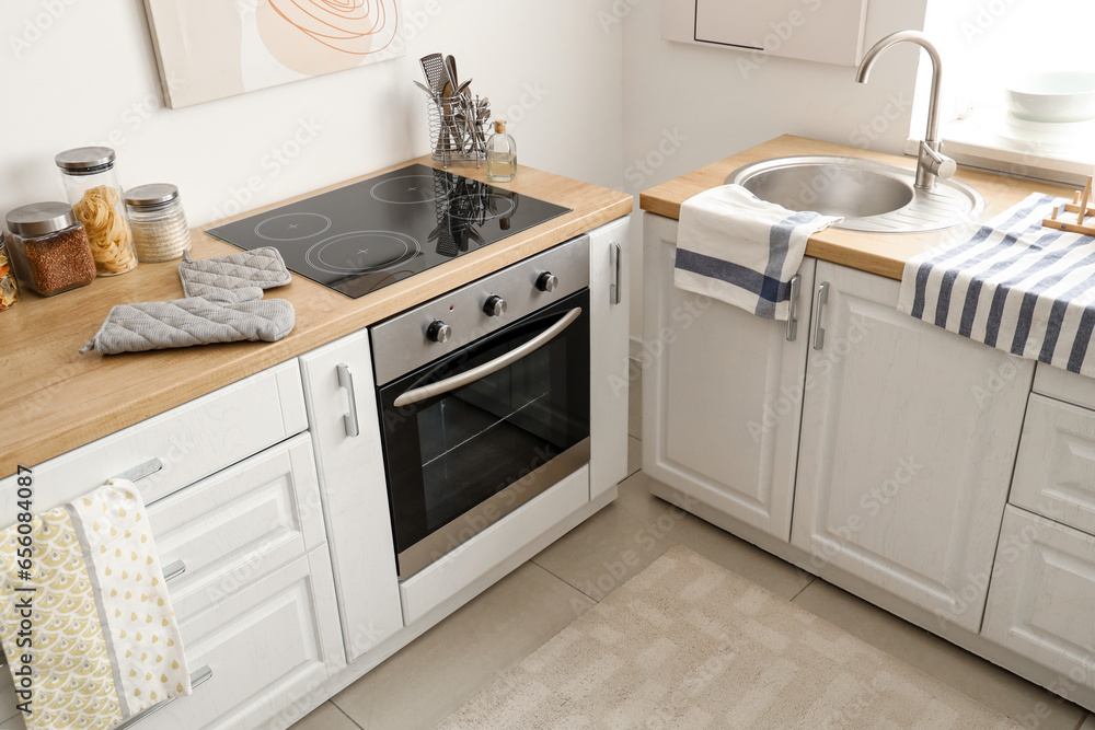 Interior of light kitchen with white counters and oven