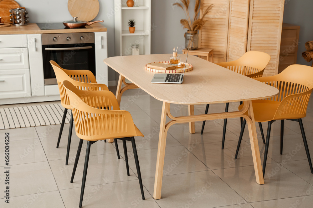 Interior of light kitchen with white counters and dining table