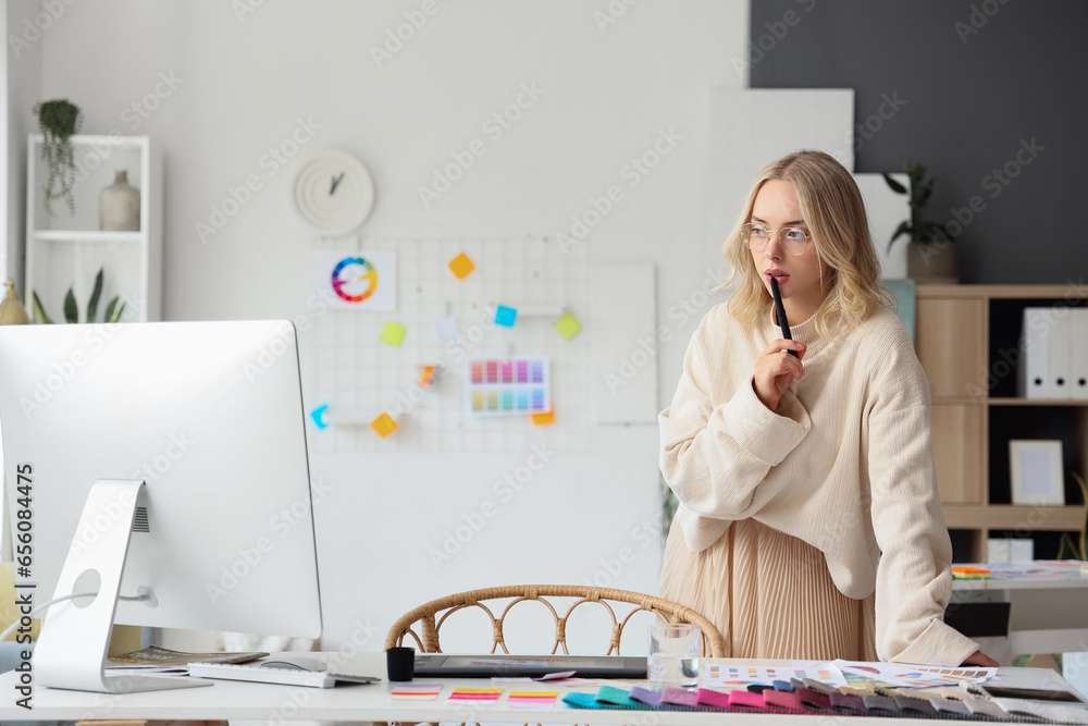 Female interior designer working with graphic tablet at table in office