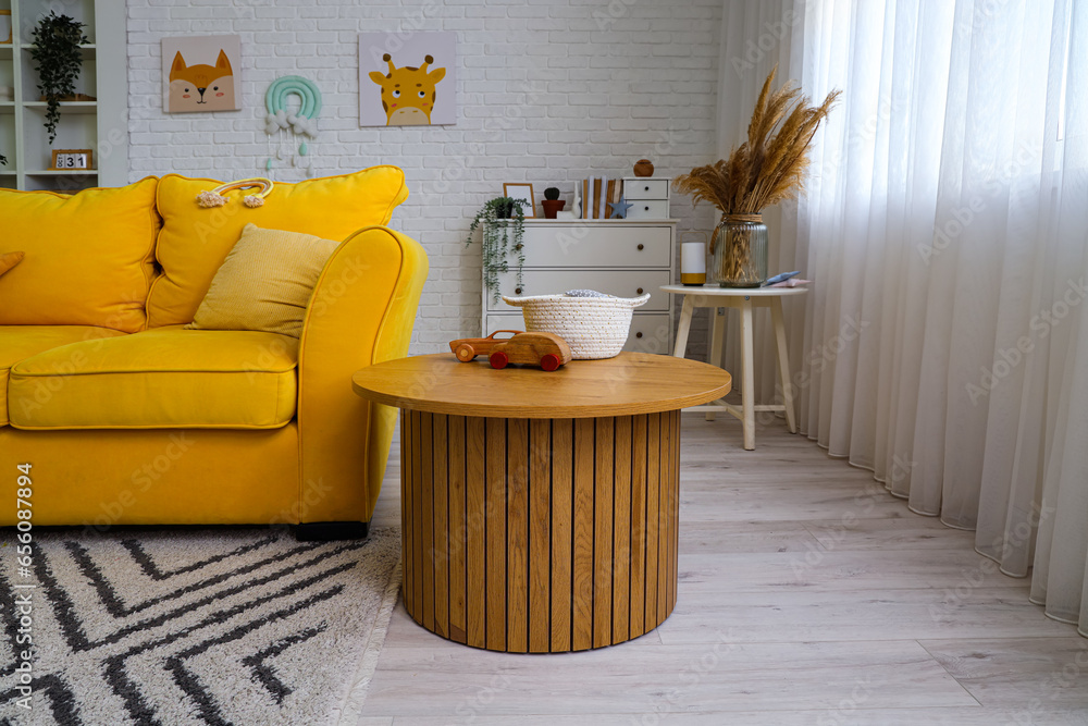 Interior of childrens room with yellow sofa and table