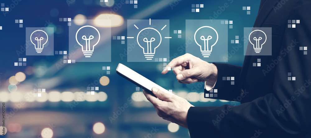 Idea light bulb theme with businessman using a tablet computer