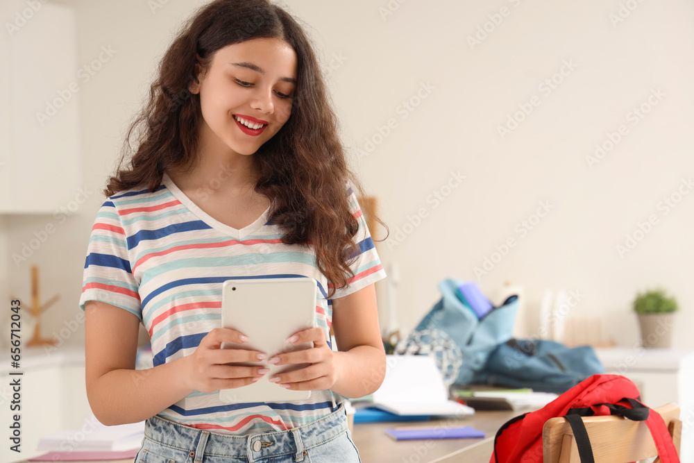 Female student with tablet computer in kitchen