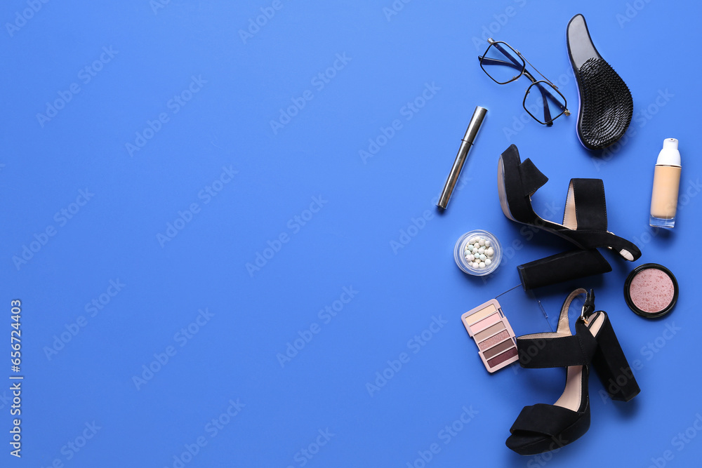 Composition with stylish female shoes, accessories and cosmetics on blue background