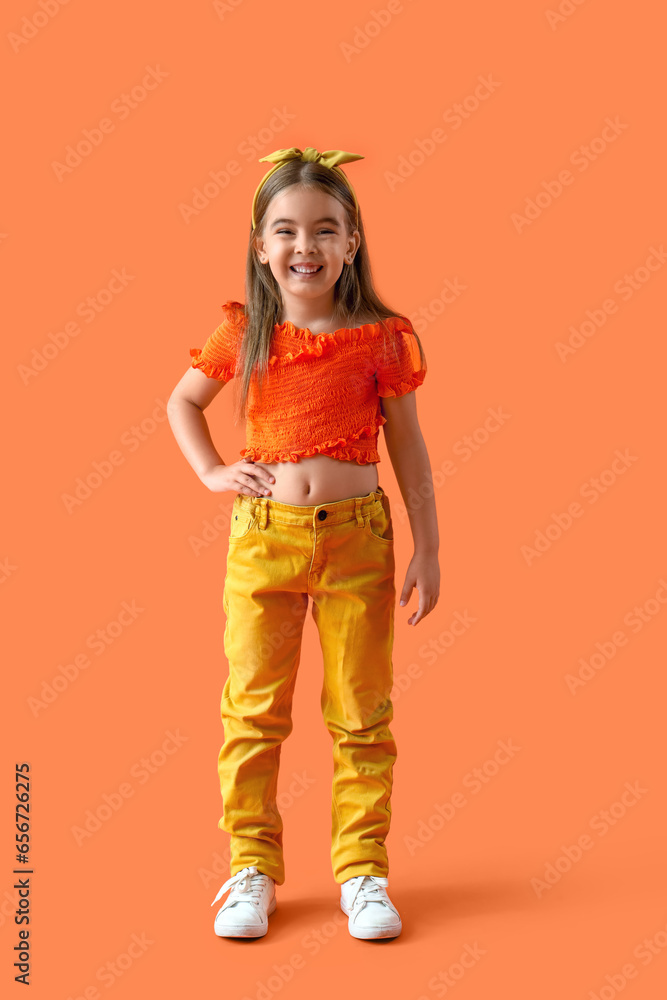 Stylish little girl on orange background