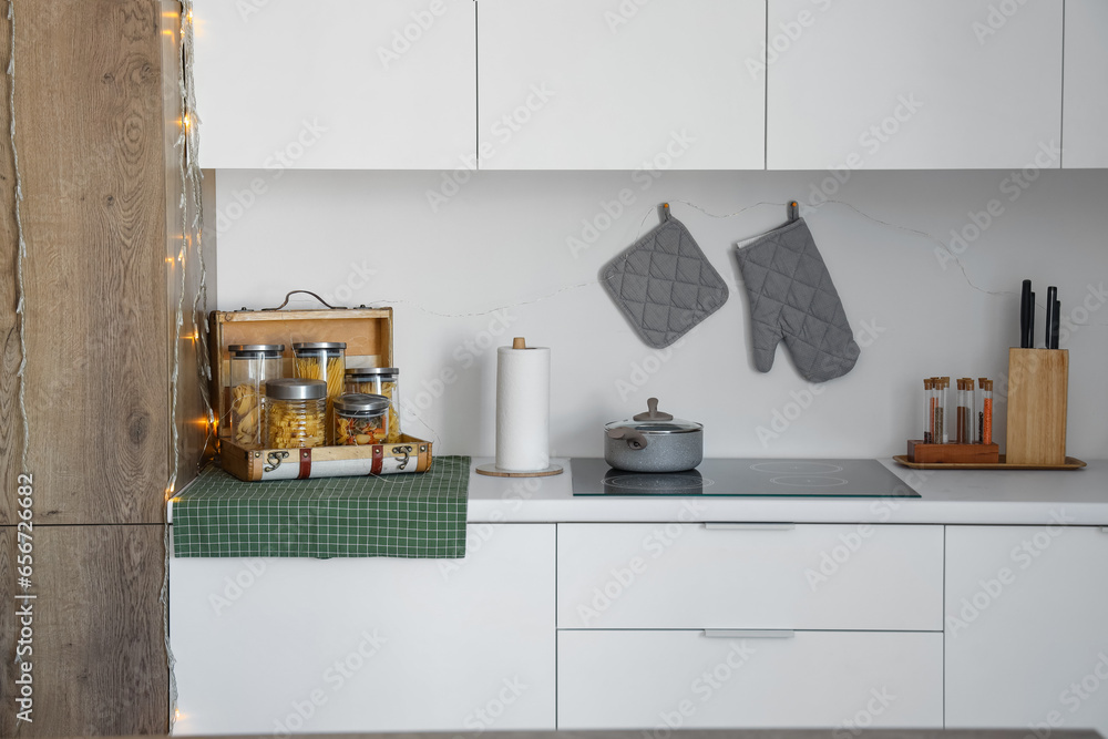 Kitchen counters with glowing lights, wooden suitcase and electric stove. Christmas celebration