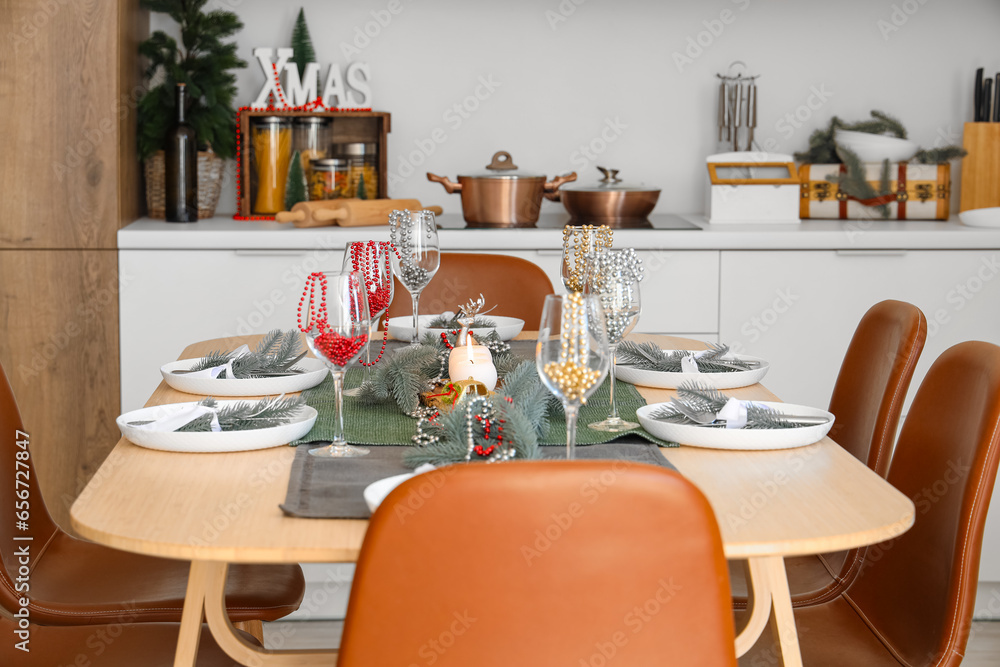 Beautiful table setting with Christmas decor and beads in interior of festive kitchen