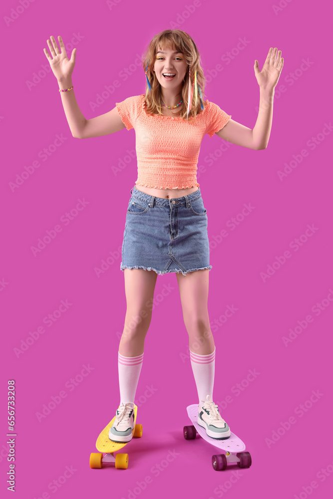 Young woman with skateboard on purple background