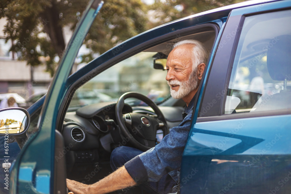 Happy senior man with blue shirt getting out of car in town. Smiling successful Caucasian businessman getting out of his car.