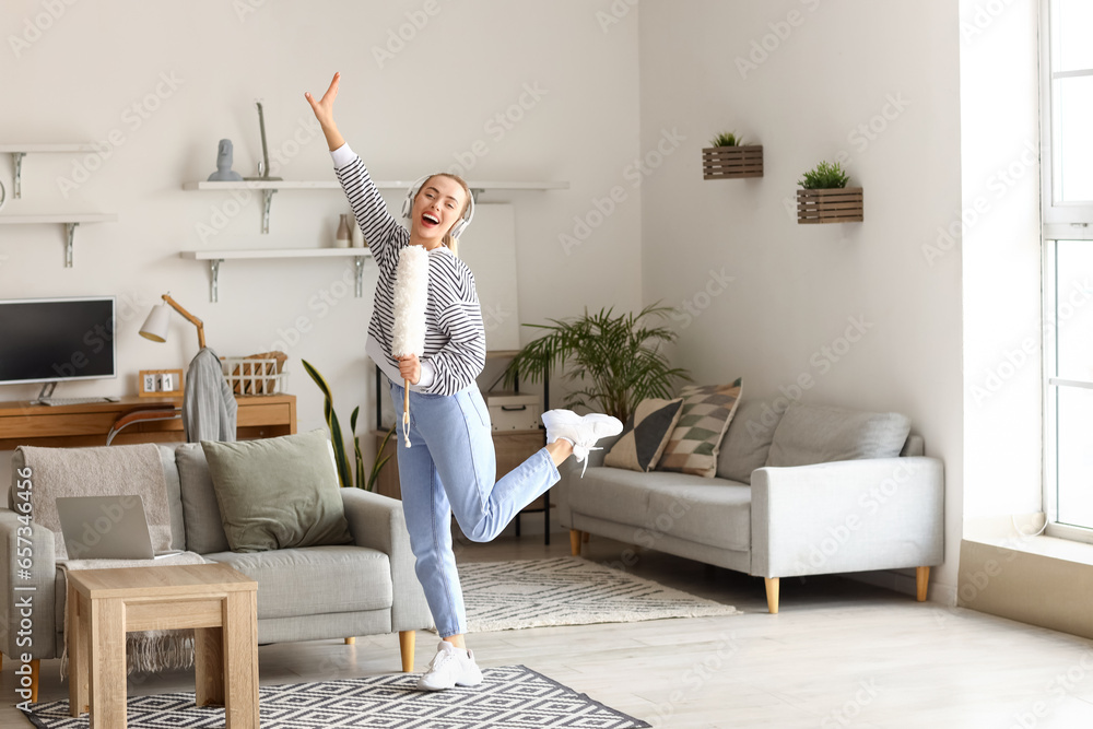 Young woman with pp-duster singing at home