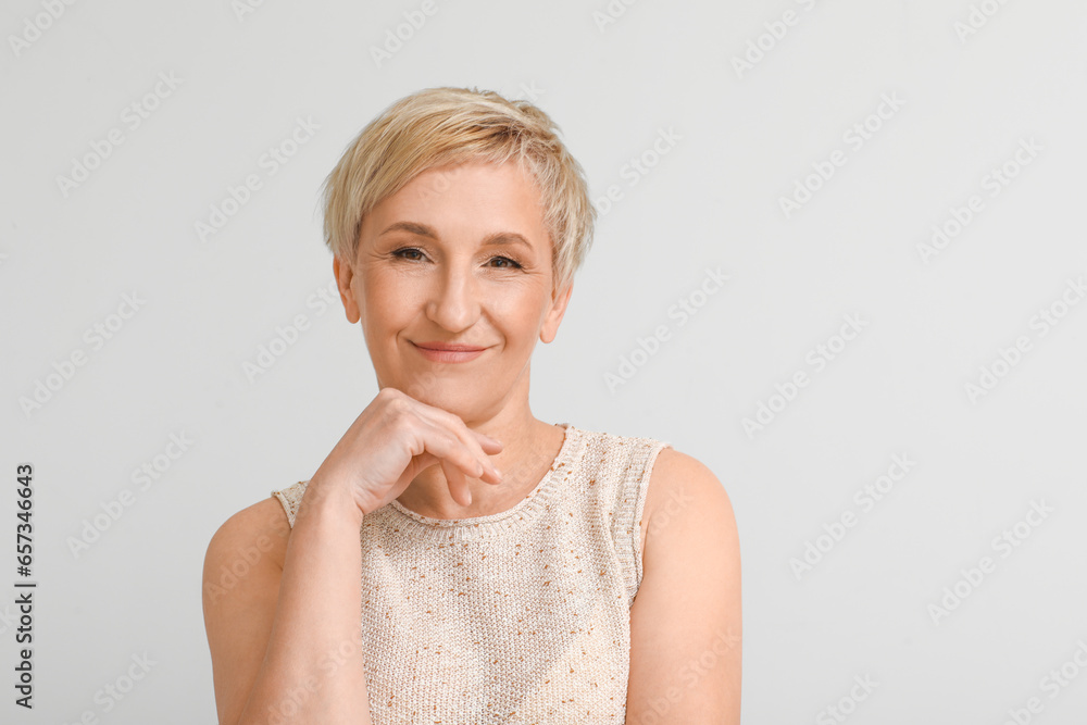 Mature blonde woman on light background