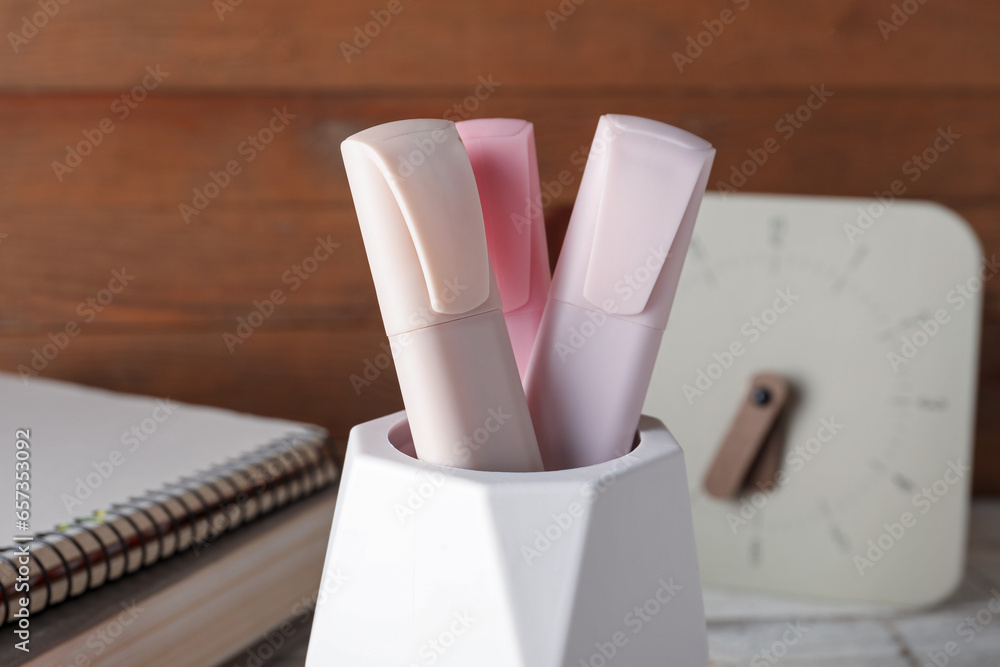 Holder with markers, notebooks and clock, closeup