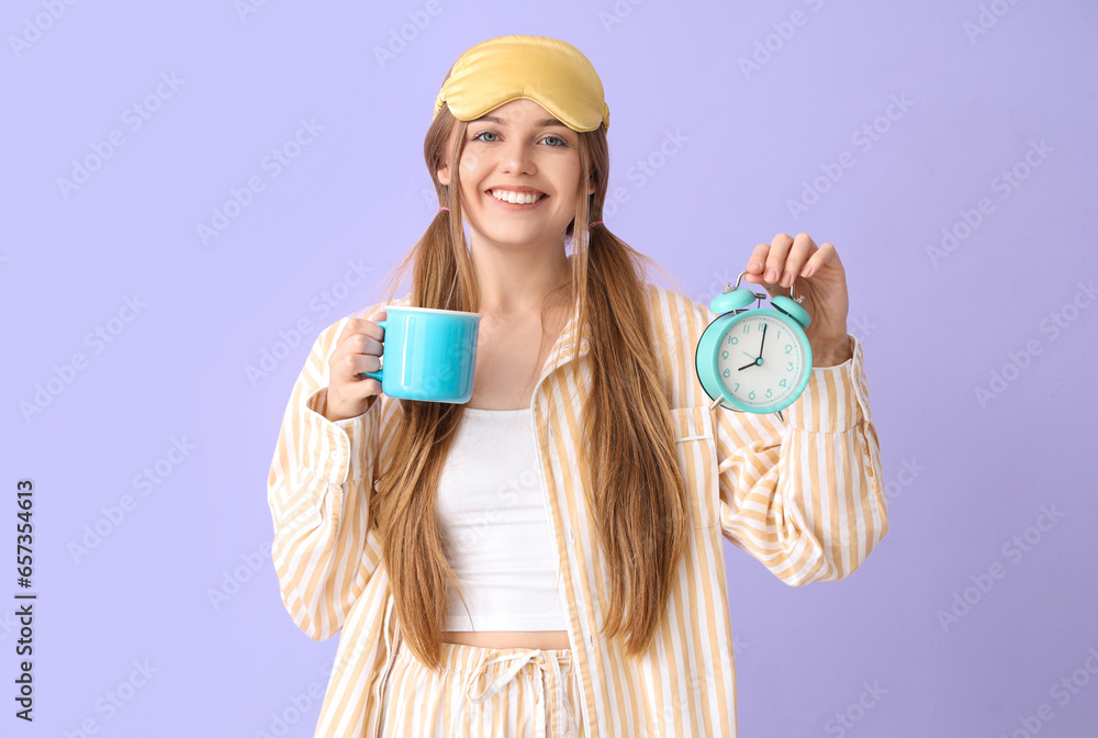 Beautiful young woman with cup of coffee and alarm clock on lilac background