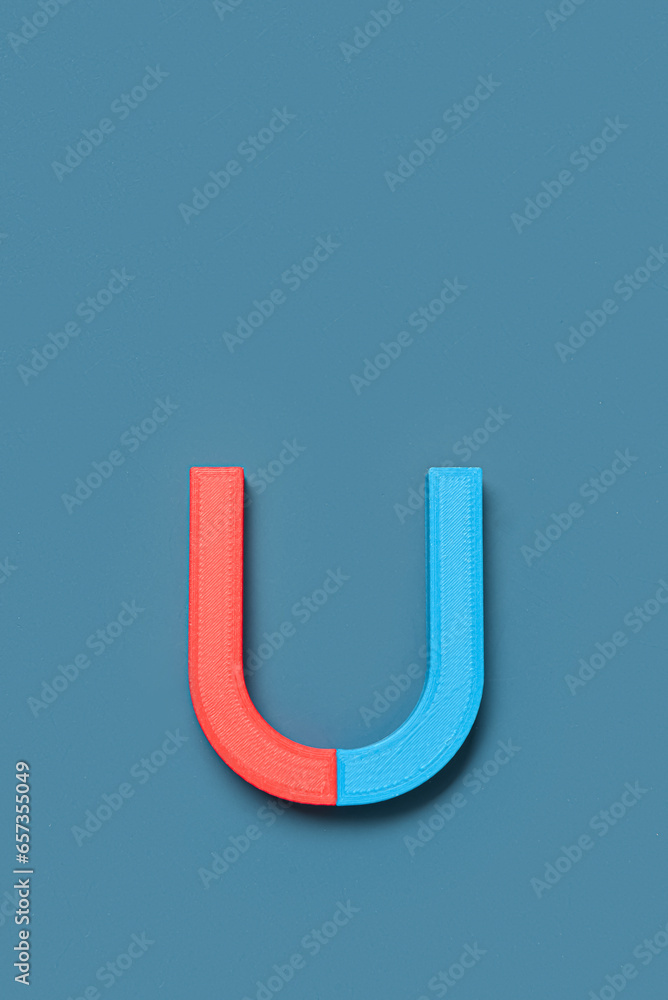 Horseshoe shaped magnet on blue background