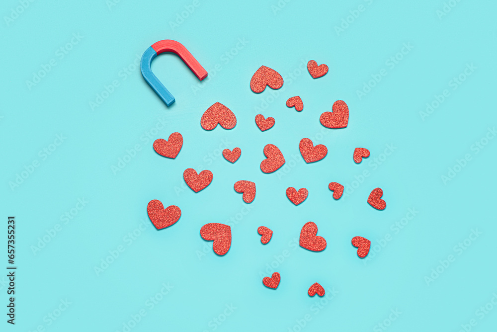 Magnet with paper hearts on blue background. Love concept