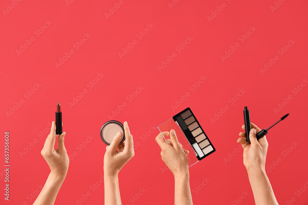 Women with makeup products on red background