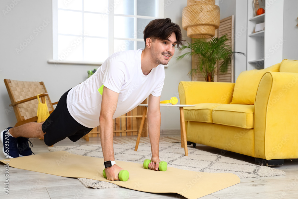 Sporty young man doing exercise at home