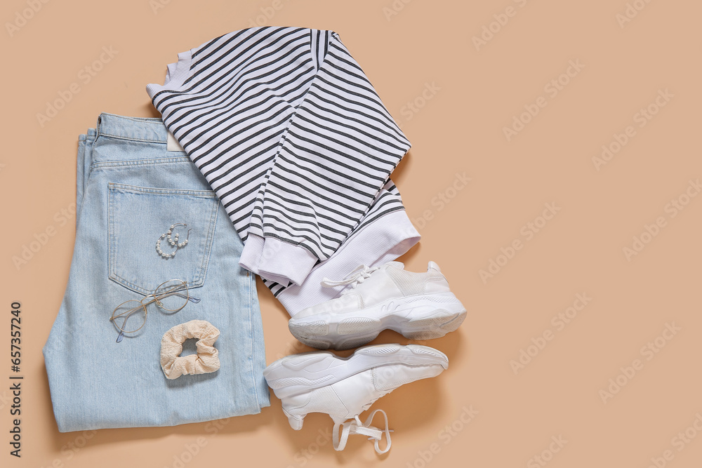 Set of stylish female clothes with accessories and sneakers on color background