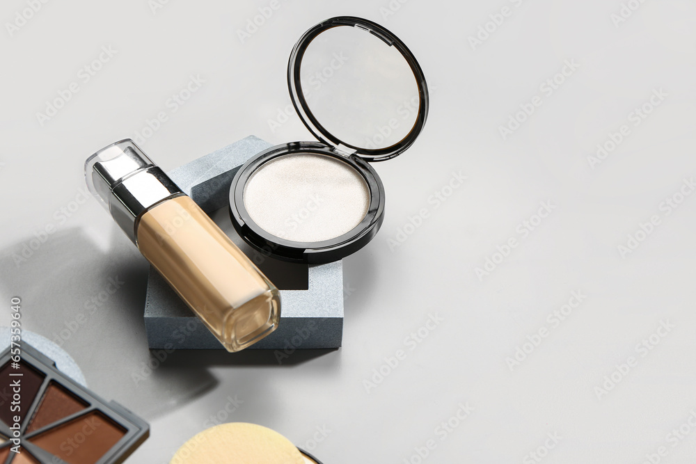 Stands with different decorative cosmetics on grey background