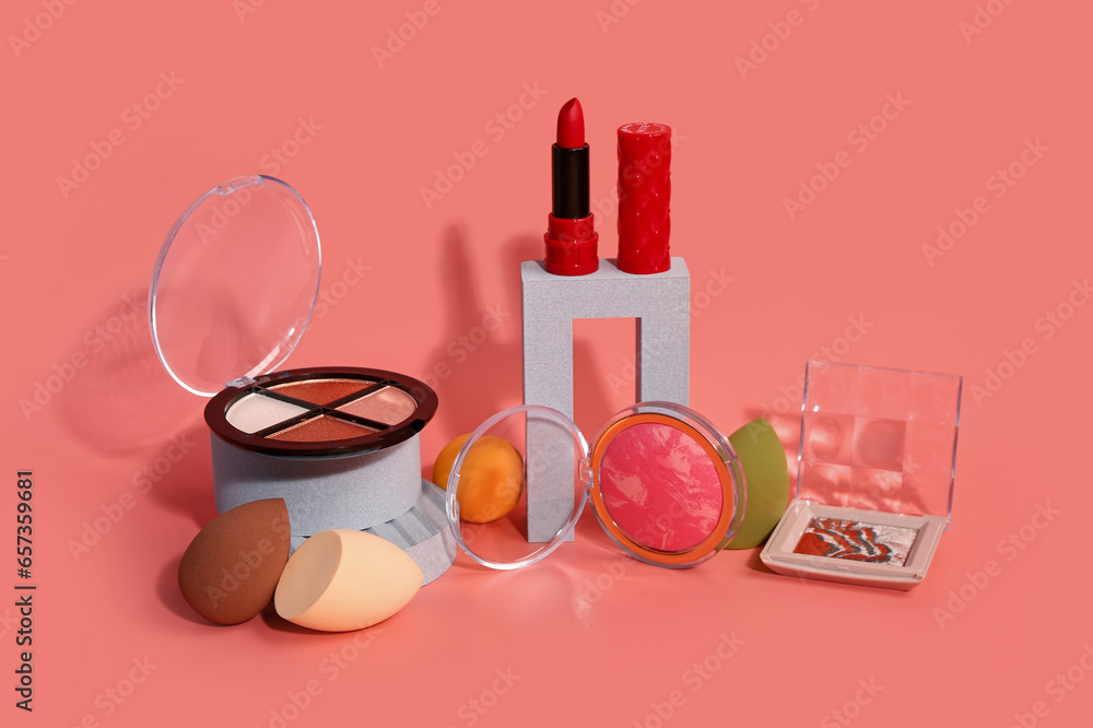 Stands with different decorative cosmetics on pink background