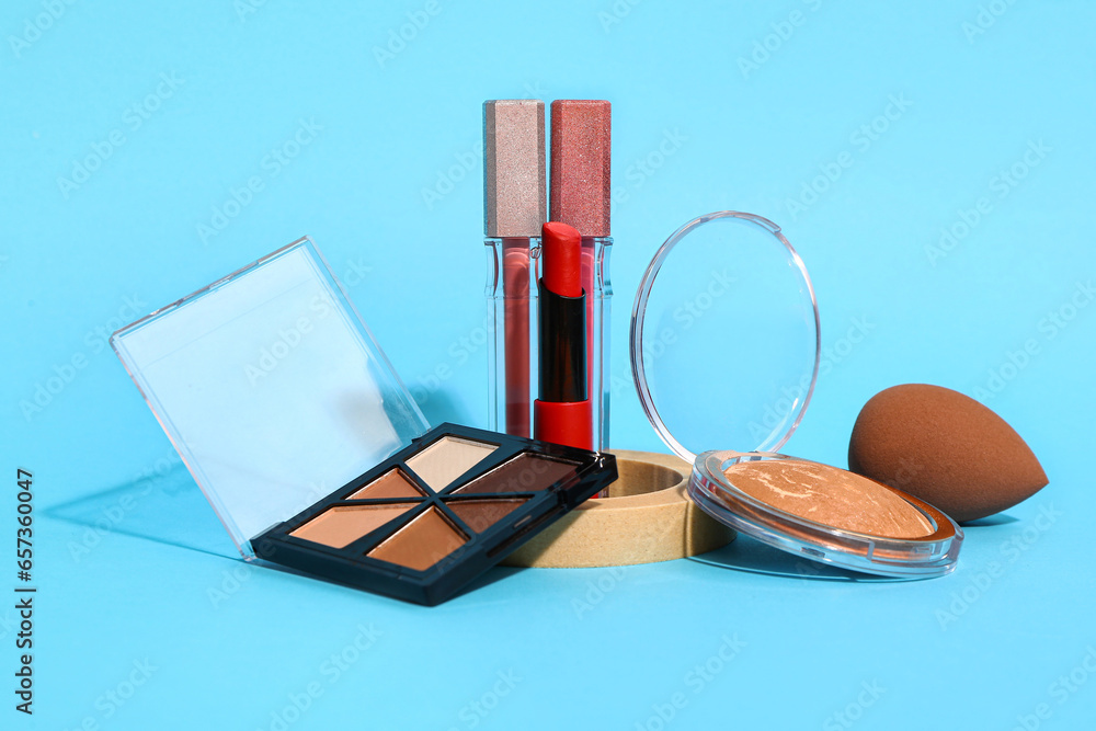 Different makeup cosmetics on blue background