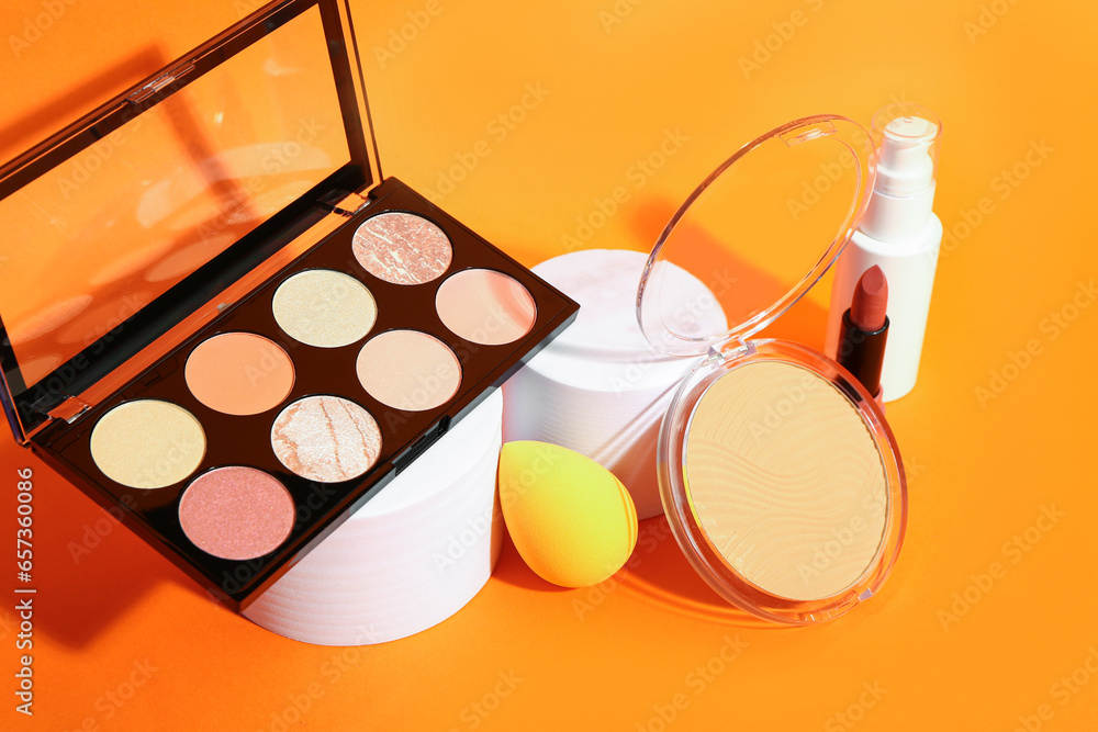 Different makeup cosmetics on orange background, closeup