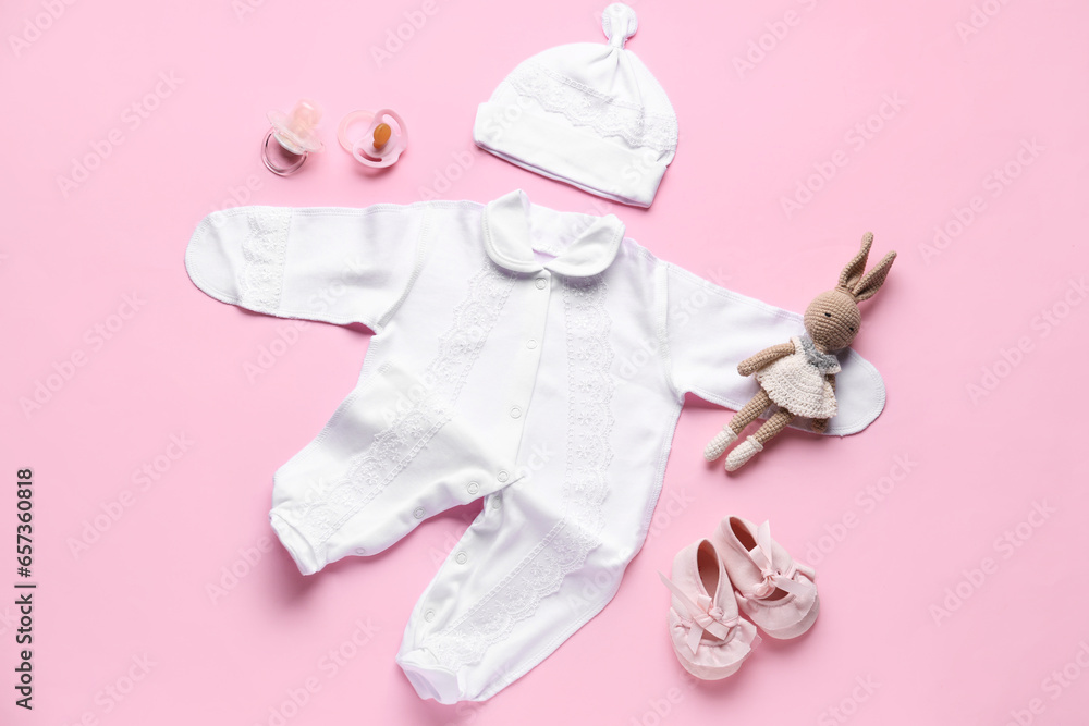 Composition with stylish baby clothes, accessories and toy on pink background