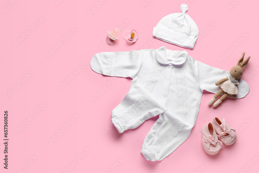 Composition with stylish baby clothes, accessories and toy on pink background