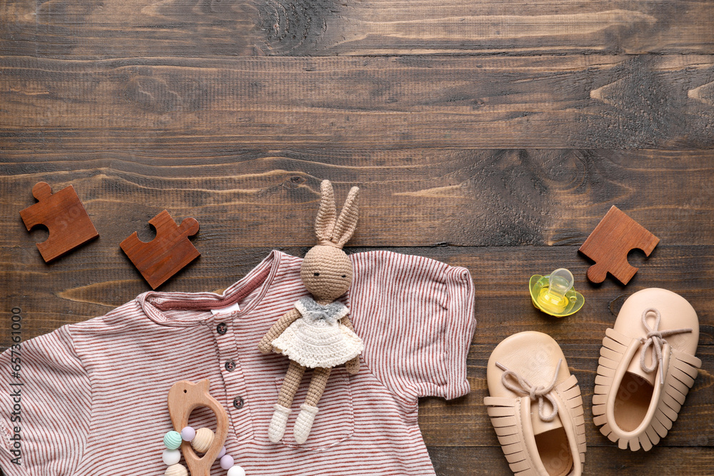 Composition with baby accessories and clothes on wooden background