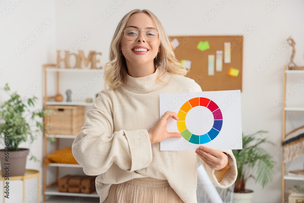 Female interior designer with color palette making heart gesture in office