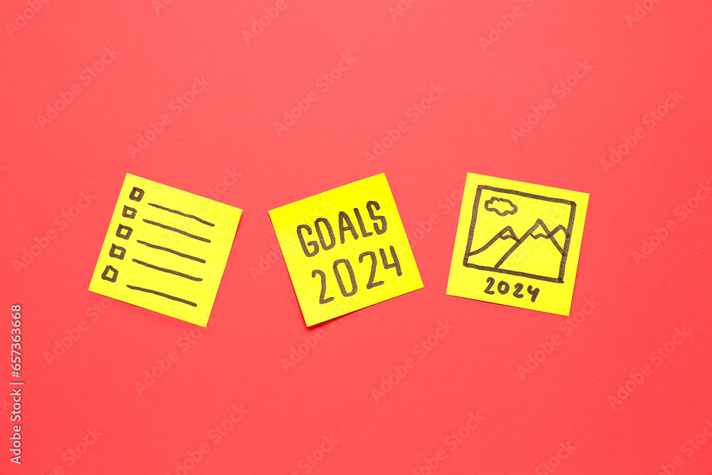 Sticky notes with different goals for 2024 on red background