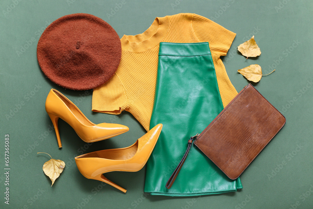 Composition with stylish female clothes, accessories and autumn leaves on color background