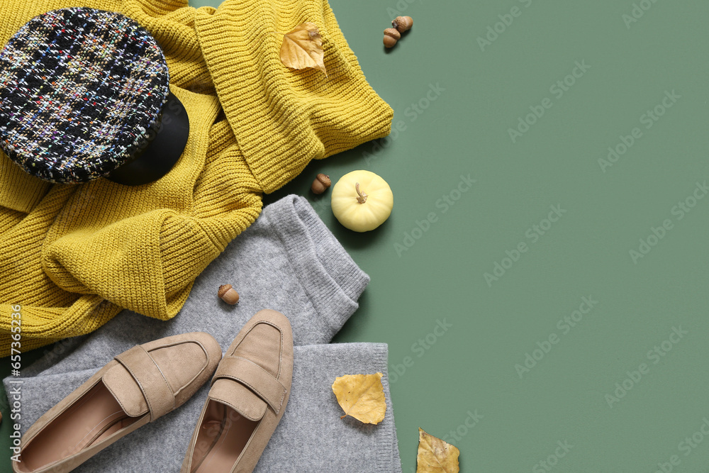 Composition with stylish female clothes, shoes and autumn decor on green background