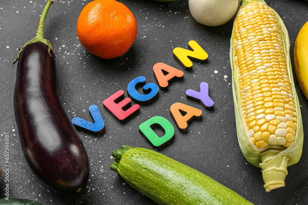 Text VEGAN DAY with fresh vegetables and fruits on black background