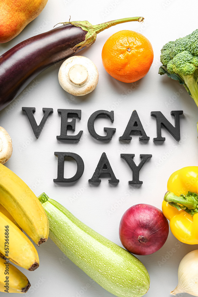 Fresh vegetables and fruits with text VEGAN DAY on grey background