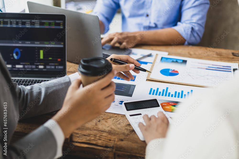 Financial consulting business meeting together to discuss financial chart analysis and brainstorm company budget planning.