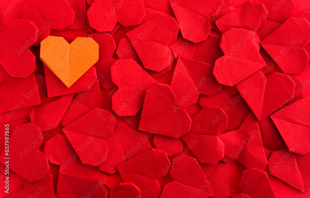 Orange origami heart on red origami hearts