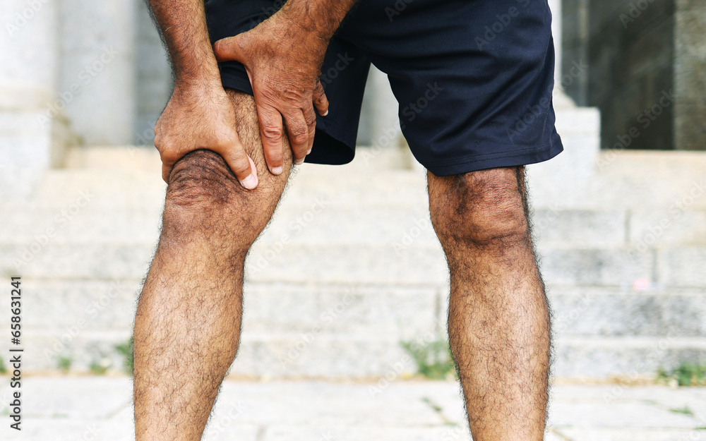 Man, hands and legs with injury, pain or ache in sports accident, emergency or outdoor exercise. Closeup of male person with sore knee, muscle or tension from workout, fitness or training mistake