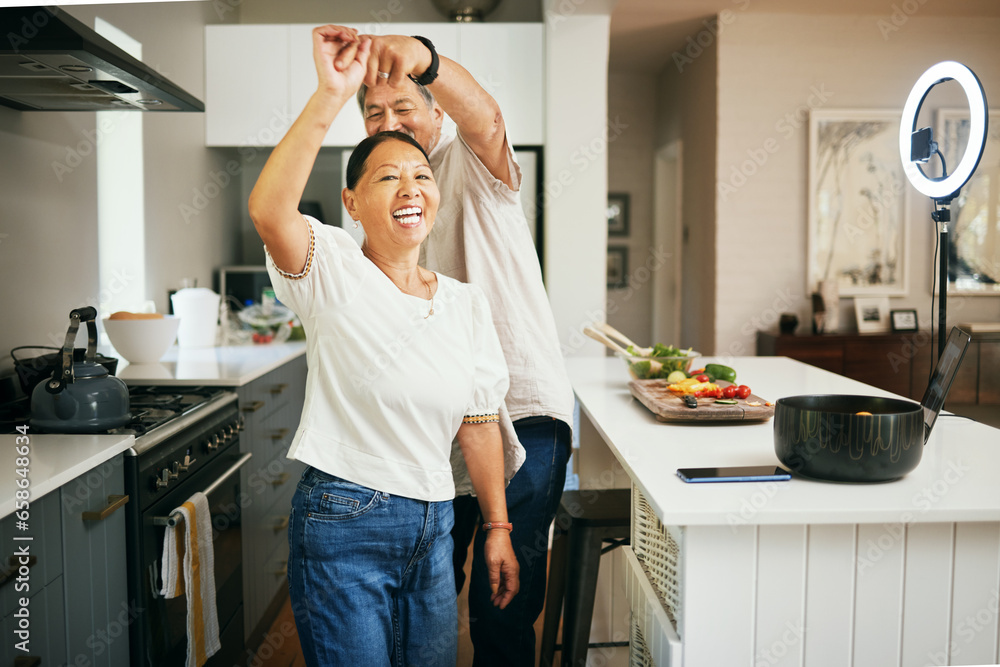 Happy couple, together and dancing while cooking in kitchen for fun, energy or bond in romance. Asian people, married and smile for love, excited or laugh with spin with preparation of dinner in home