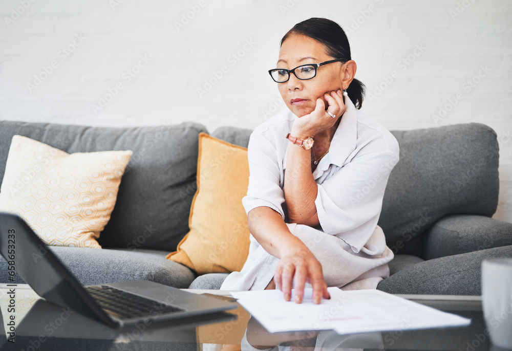 Woman thinking, laptop and documents with home budget, life insurance research or financial paperwork on sofa. Mature person on computer, reading information and registration for loan, bank or policy