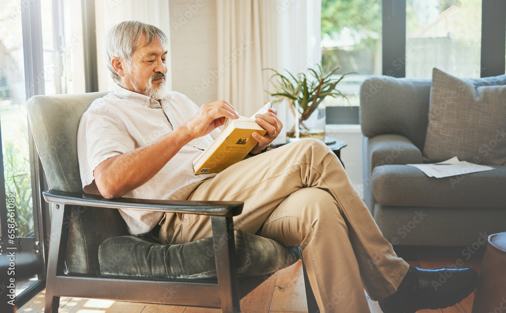 Relax, book and a senior asian man reading on a chair in the living room of his home during retirement. Study, learning and elderly person pensioner in his house alone for a literature leisure hobby