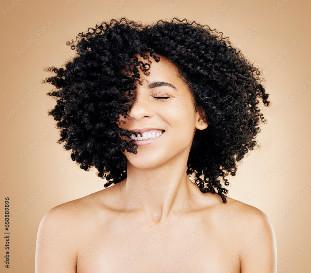 Happy woman, curly or afro hair wind on fun studio background for healthy hairstyle growth, texture or frizz treatment. African beauty model, shake energy and change by shampoo transformation results